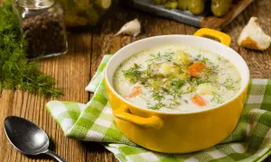 Aksamitna zupa ogórkowa z ziemniakami, ozdobiona świeżym koperkiem. Idealne zioła do zupy ogórkowej z ziemniakami to właśnie koperek i czosnek.