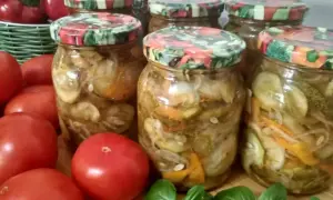Słoiki z ogórkami i warzywami w zalewie, obok pomidorów i papryki.