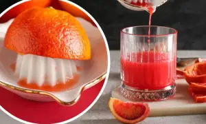 Sok z grejpfruta w szklance, wyciskany z owocu na wyciskarce.