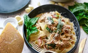 Pyszna carbonara z kurczakiem, podana z parmezanem, bazylią i czosnkiem. Idealna na obiad.