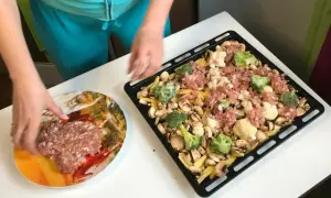 Przygotowanie pysznego obiadu z piekarnika: ziemniaki, pieczarki, brokuły i mielone mięso na blasze.