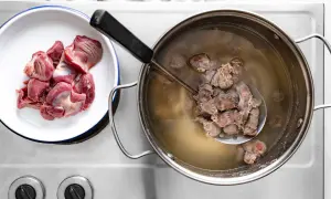 Surowe i gotujące się żołądki drobiowe, gotowe na gulasz. Jakie przyprawy do gulaszu z żołądków?