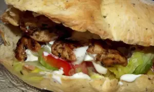 Kebab w picie z grillowanym kurczakiem, warzywami i sosem.
