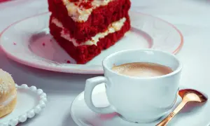 Kawa i kawałek ciasta Red Velvet na talerzyku.