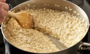 Gotowanie kremowego risotto w garnku, mieszane drewnianą łyżką.
