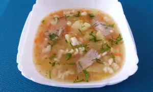 Pyszna zupa na żeberkach wieprzowych z ziemniakami, marchewką i makaronem, posypana natką pietruszki.