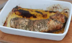 Pieczona polędwica wieprzowa w ziołach, w białym naczyniu żaroodpornym. Idealna do niedzielnego obiadu, zastanawiasz się polędwica wieprzowa ile piec?