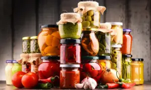 Słoiki z przetworami: warzywa, owoce, oliwki, papryka, pomidory, czosnek, cebula, chili.