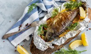 Pieczony pstrąg w folii aluminiowej z cytryną i koperkiem.