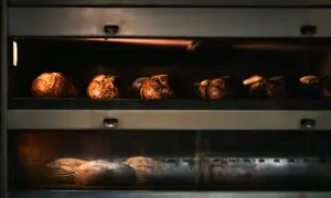 Kilka bochenków chleba piecze się w piekarniku, na dwóch poziomach.