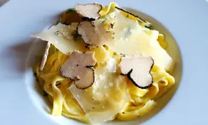 Tagliatelle z truflami ze słoika, posypane płatkami parmezanu. Luksusowy smak w każdym kęsie.