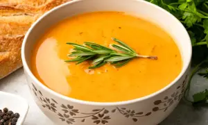 Aromatyczna zupa krem z gałązką rozmarynu, podana z chrupiącą bagietką i czarnym pieprzem. Idealna na chłodne dni.