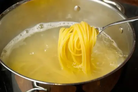 Złocisty makaron spaghetti gotuje się w garnku. Zastanawiasz się, ile kalorii ma makaron spaghetti?