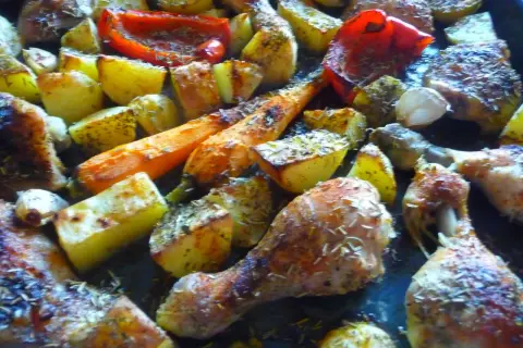 Pyszny pomysł na obiad z piekarnika: pieczony kurczak z ziemniakami, marchewką i papryką, doprawiony ziołami.