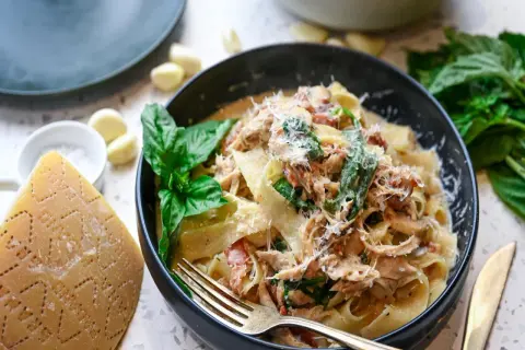 Pyszna carbonara z kurczakiem, podana z parmezanem, bazylią i czosnkiem. Idealna na obiad.