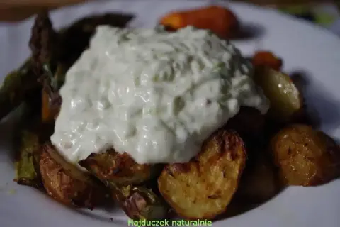 Gęsty sos tzatziki na pieczonych ziemniakach i warzywach.