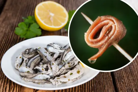 Anchois na talerzu i pojedynczy filet na wykałaczce, obok cytryna i natka.