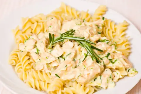 Fusilli z kurczakiem w kremowym sosie, udekorowane rozmarynem.