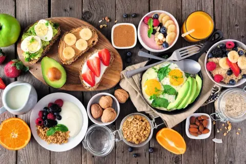 Sycące śniadanie: tosty z awokado i jajkiem, owsianka, jogurt z owocami, jajecznica, smoothie bowl, sok pomarańczowy.
