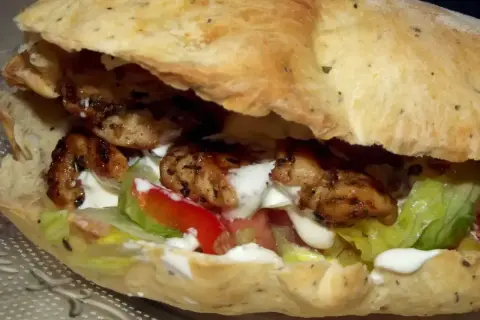 Kebab w picie z grillowanym kurczakiem, warzywami i sosem.