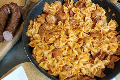 Szybkie danie z kiełbasą i makaronem farfalle w sosie pomidorowym. Idealne na obiad, gdy brakuje czasu.