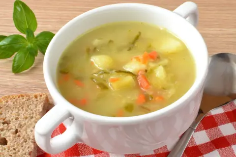 Jak przyprawić zupę ogórkową? Aromatyczna zupa z ziemniakami, marchewką i ogórkiem kiszonym, podana z chlebem i bazylią.