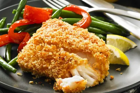 Chrupiący filet rybny w panierce panko z fasolką szparagową, papryką i cytryną.