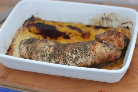 Pieczona polędwica wieprzowa w ziołach, w białym naczyniu żaroodpornym. Idealna do niedzielnego obiadu, zastanawiasz się polędwica wieprzowa ile piec?
