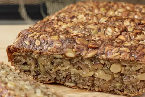Keto chleb z ziarnami i orzechami, pokrojony na kromki.