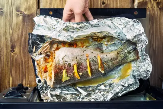 Pieczona ryba morska w folii aluminiowej z cytryną i ziołami.