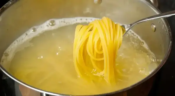 Złocisty makaron spaghetti gotuje się w garnku. Zastanawiasz się, ile kalorii ma makaron spaghetti?