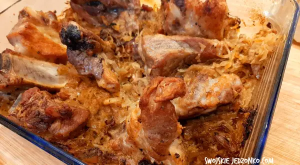 Pieczone żeberka w kiszonej kapuście w szklanym naczyniu.