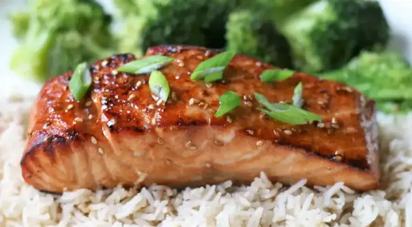 Łosoś w sosie teriyaki z ryżem i brokułami, posypany sezamem i szczypiorkiem.