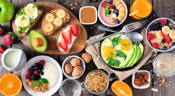 Sycące śniadanie: tosty z awokado i jajkiem, owsianka, jogurt z owocami, jajecznica, smoothie bowl, sok pomarańczowy.