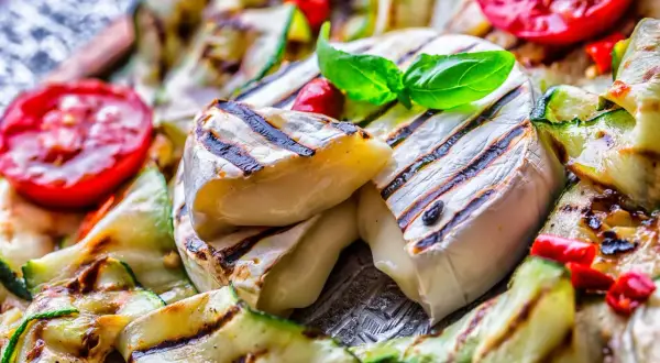 Grillowany ser camembert z cukinią, pomidorami i bazylią.