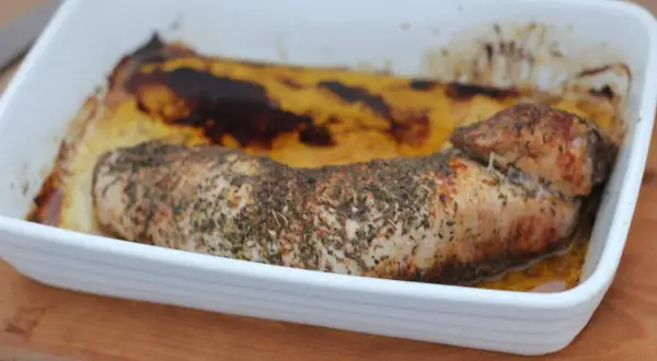 Pieczona polędwica wieprzowa w ziołach, w białym naczyniu żaroodpornym. Idealna do niedzielnego obiadu, zastanawiasz się polędwica wieprzowa ile piec?