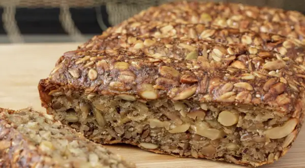 Keto chleb z ziarnami i orzechami, pokrojony na kromki.