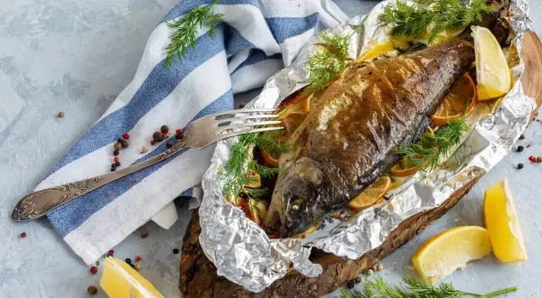 Pieczony pstrąg w folii aluminiowej z cytryną i koperkiem.