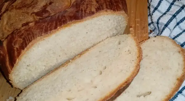 Pokrojony bochenek domowego chleba z chrupiącą skórką i miękkim wnętrzem.