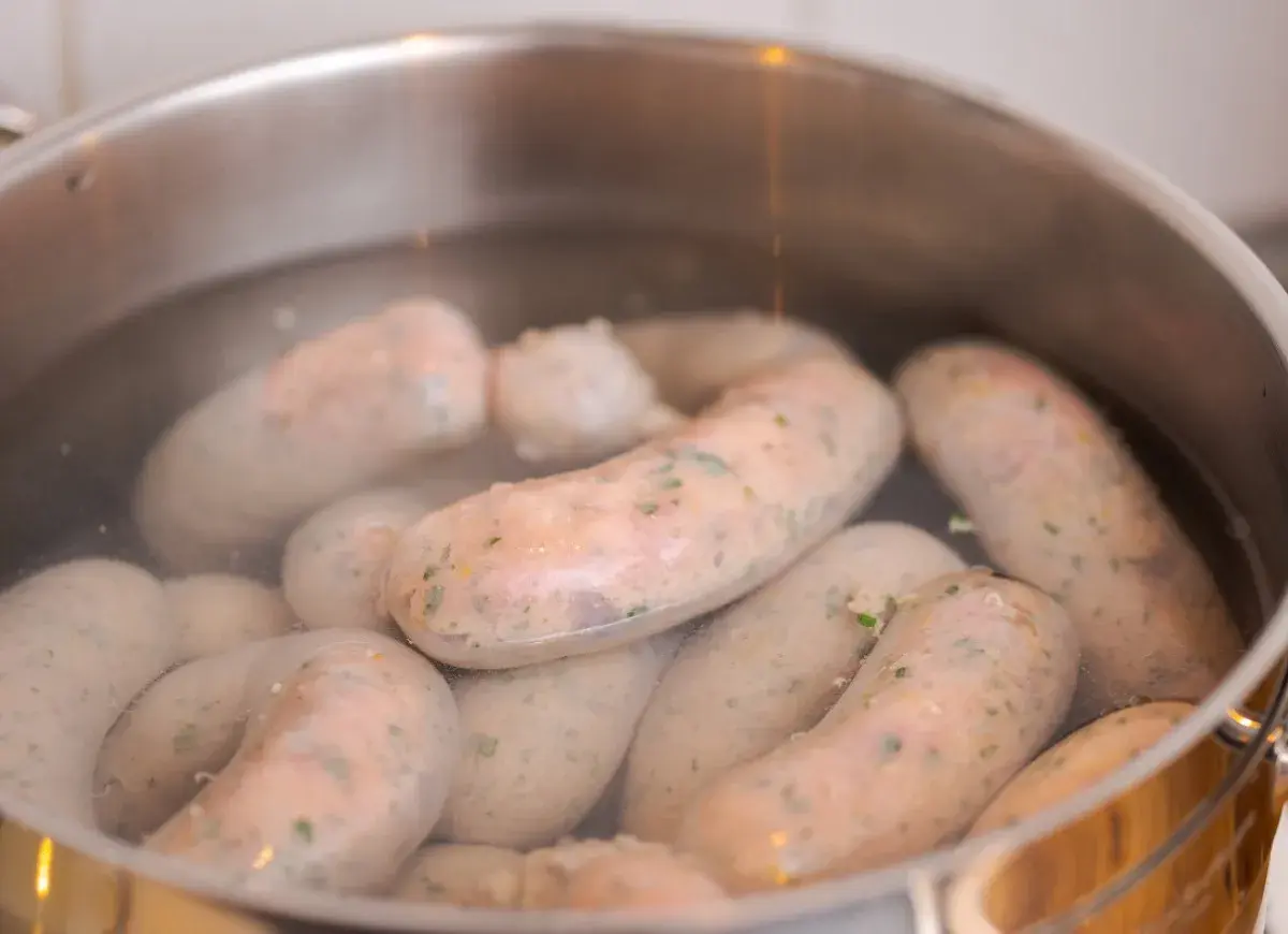 Biała kiełbasa gotuje się w garnku. Kluczowa jest odpowiednia temperatura parzenia, by była soczysta.