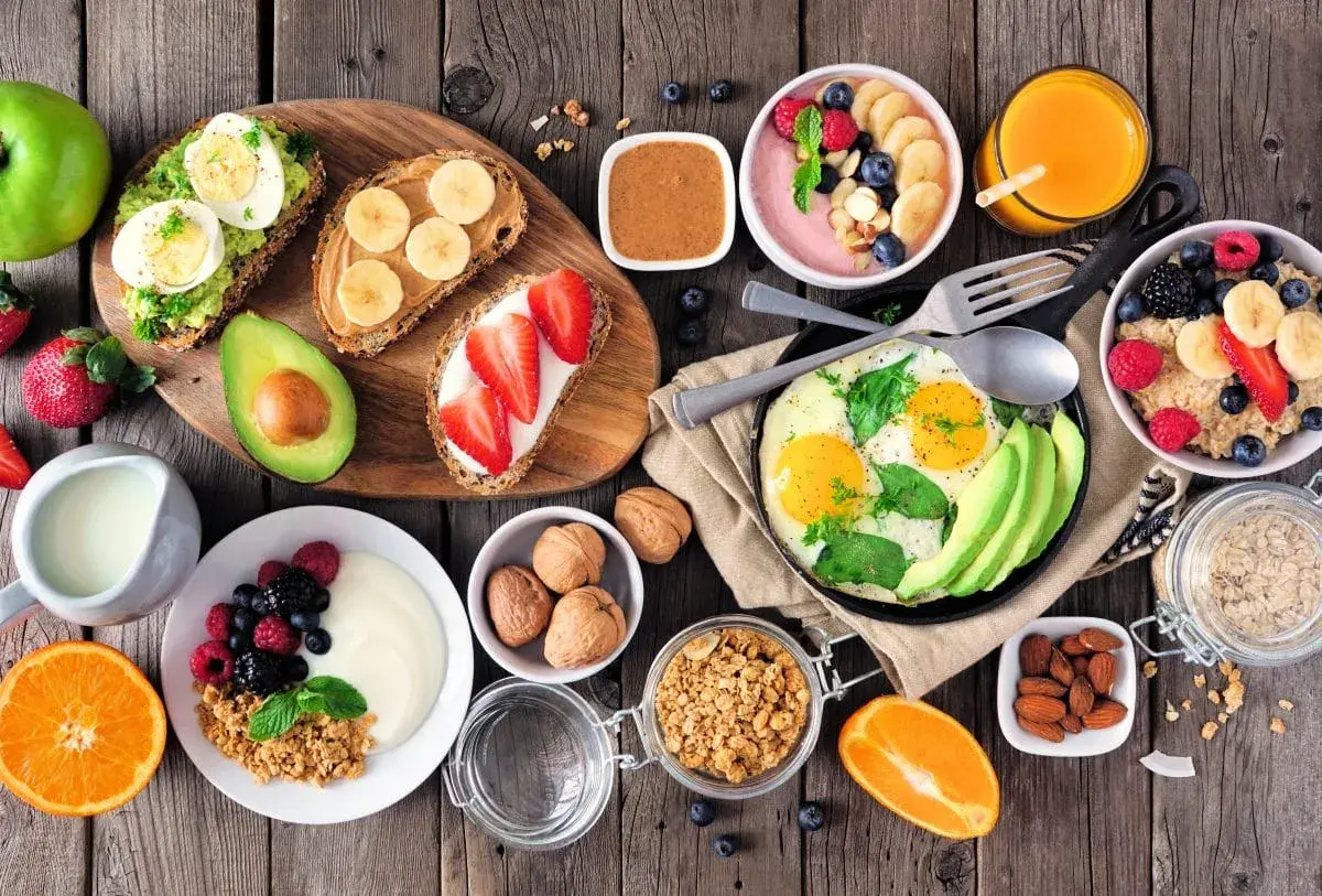 Sycące śniadanie: tosty z awokado i jajkiem, owsianka, jogurt z owocami, jajecznica, smoothie bowl, sok pomarańczowy.
