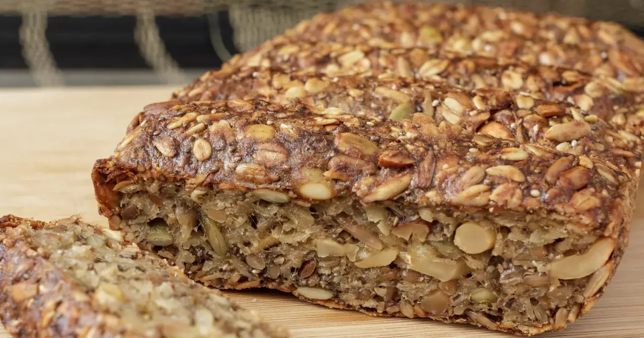 Keto chleb z ziarnami i orzechami, pokrojony na kromki.