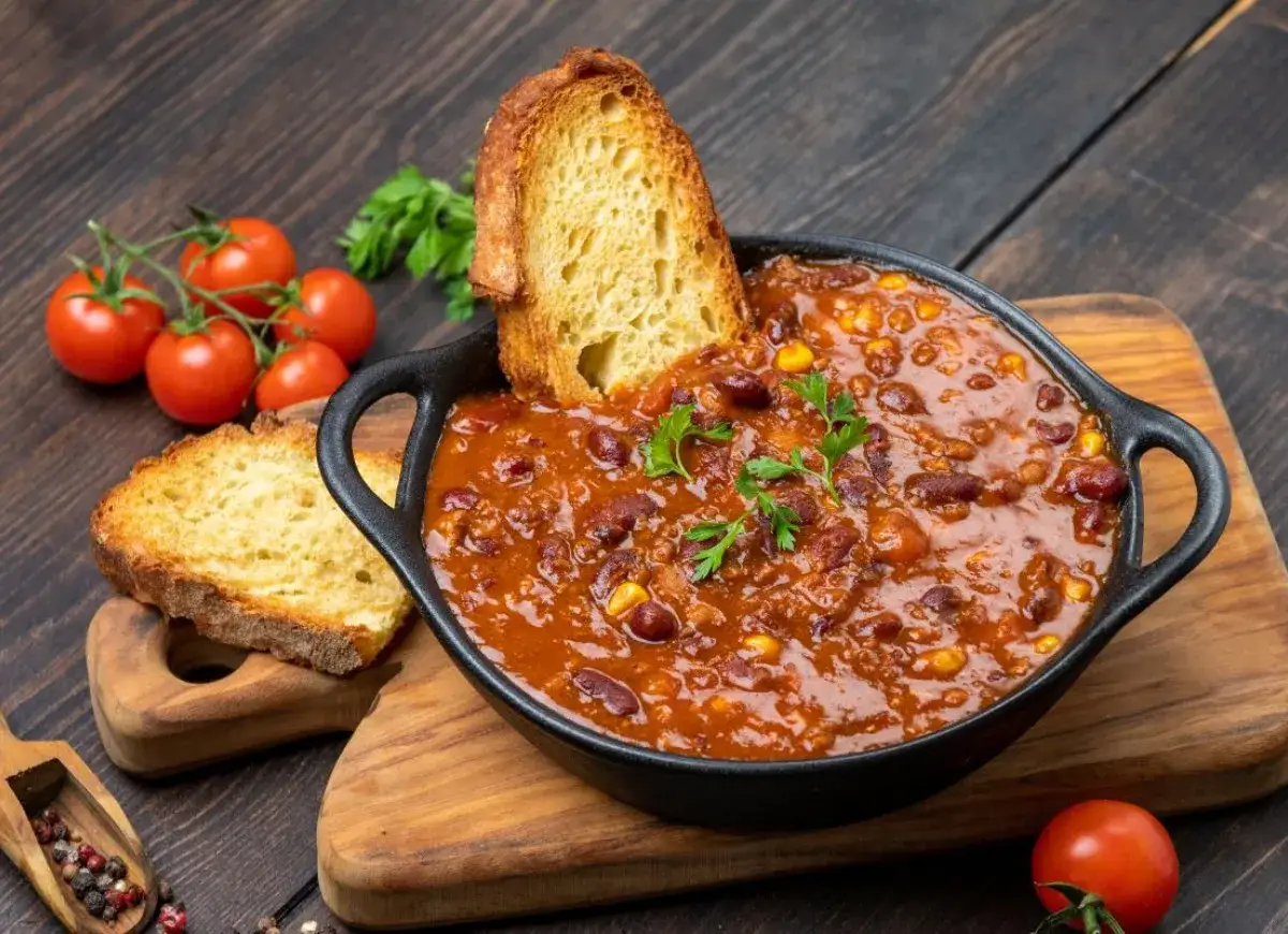 Pyszne chili con carne z fasolą i kukurydzą, podane z chrupiącym pieczywem. Idealne co na obiad na kilka dni, sycące i aromatyczne.