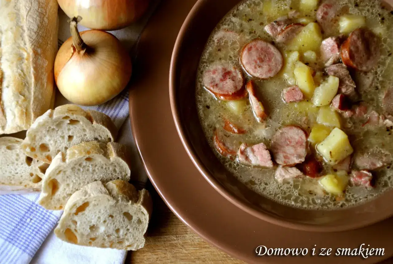 Gęsta zupa na żeberkach wieprzowych z ziemniakami i kiełbasą, podana z chlebem i cebulą. Domowo i ze smakiem.