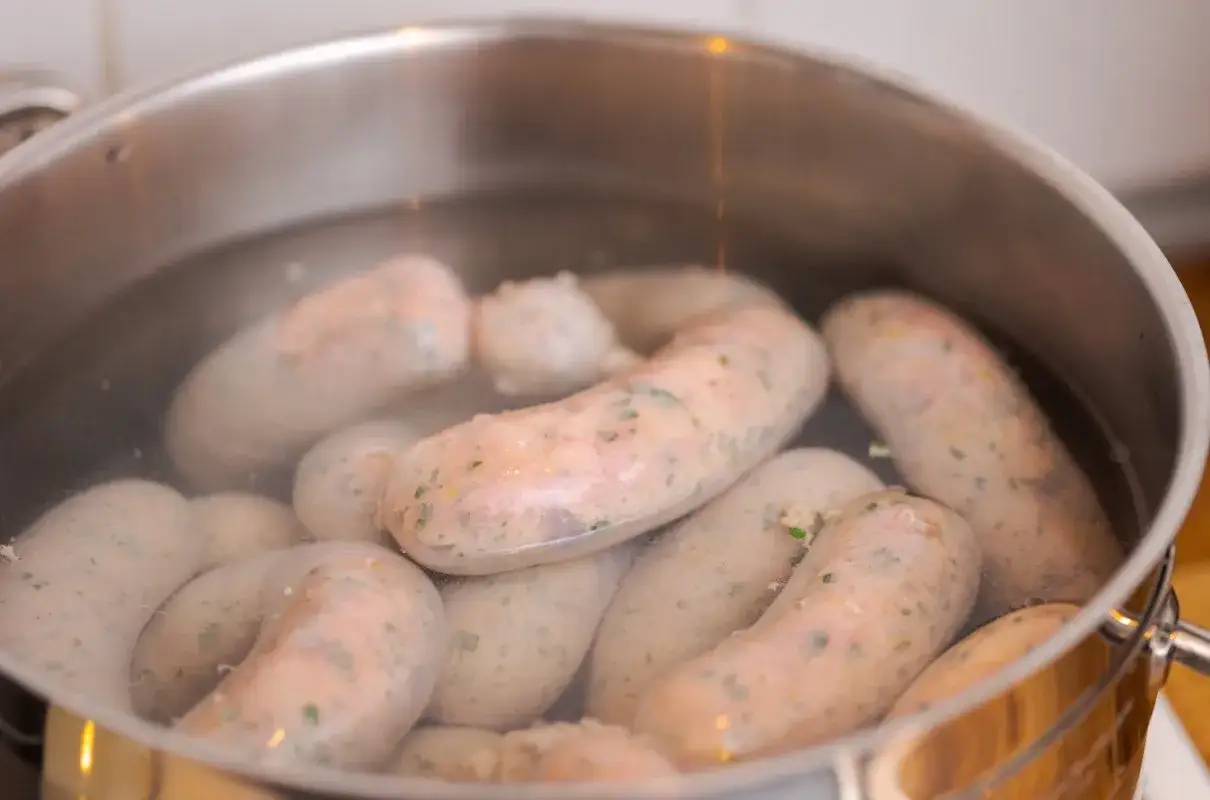 Kiełbasa parzy się w garnku z wodą. Idealna temperatura do parzenia kiełbasy po wędzeniu to około 70-75°C.