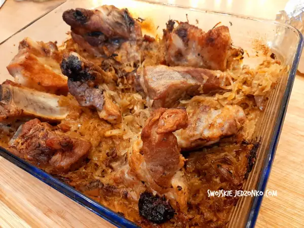 Pieczone żeberka w kiszonej kapuście w szklanym naczyniu.