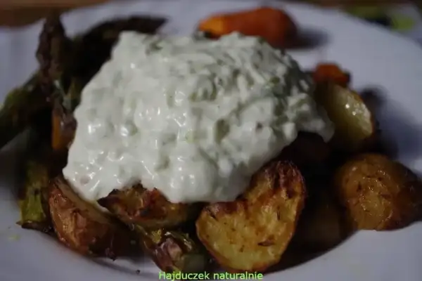 Gęsty sos tzatziki na pieczonych ziemniakach i warzywach.