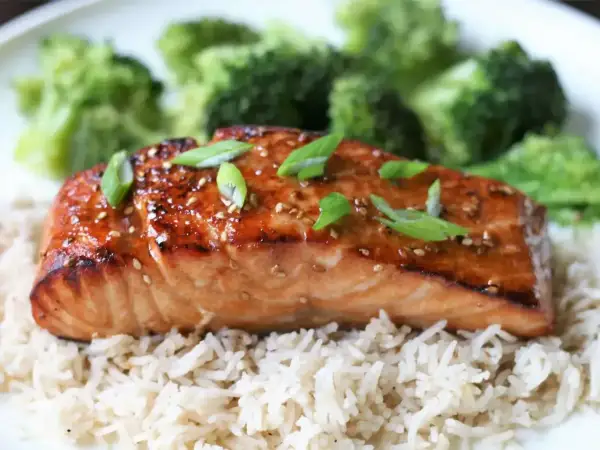 Łosoś w sosie teriyaki z ryżem i brokułami, posypany sezamem i szczypiorkiem.