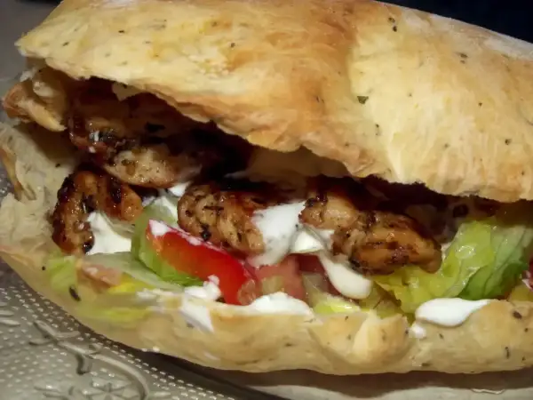 Kebab w picie z grillowanym kurczakiem, warzywami i sosem.