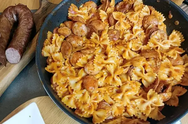 Szybkie danie z kiełbasą i makaronem farfalle w sosie pomidorowym. Idealne na obiad, gdy brakuje czasu.
